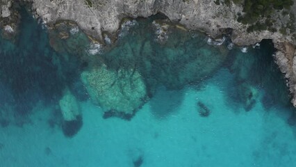 Canvas Print - Flying over a beautiful rocky coast with sea grotto and clear blue emerald water top view. Travel cpncept. Aerial view of summer seascape. Sardinia, Italy