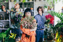 Woman Working With Florists In Flower Store