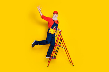 Wall Mural - full length photo of funny positive old guy dressed uniform overall red hardhat rising stairs waving