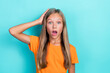 Closeup photo of young cute funny schoolgirl kid wear orange t-shirt open mouth unexpected touch head scared isolated on aquamarine color background
