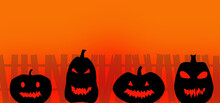 Black Pumpkins Are Depicted Against An Orange Background, Behind Them Is A Fence Lit By A Red Sunset. Halloween Concept