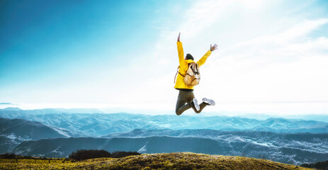 Wall Mural - Happy man with open arms jumping on the top of mountain - Hiker with backpack celebrating success outdoor - People, success and sport concept