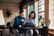 © bnenin - Businessman and businesswoman working at the office, together, over the laptop.