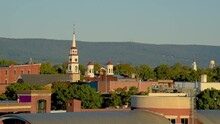 View Of Church Spires In The City Of Frederick, Maryland With Trees And A Hill In The Background.
