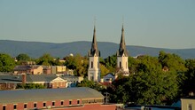 View Of Church Spires In Frederick, Maryland With A Hill And The Sky In The Background.