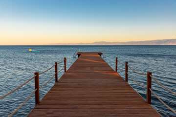  wooden pier and iron bathing ladder at sunset , space for text. calm concept