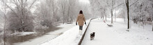 Teenager girl walking her pet dog in winter snow