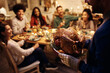 © Drazen - Close up of man serving roasted turkey during Thanksgiving dinner party with friend.