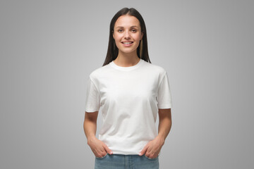 young female standing in front of camera in white t-shirt and blue jeans, isolated on gray