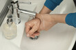 Man using water tap to rinse soap off hands in bathroom, closeup