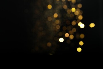 Wall Mural - blurred view of golden lights on black background. bokeh effect