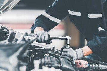 Wall Mural - Mechanic works on the engine of the car in the garage. Repair se