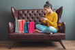 © sutthinon602 - Young woman on sofa shopping online with laptop, Young woman holding credit card and using laptop computer. Online shopping concept. Film tone