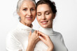 Beautiful women of different ages and generations together on a white background. Daughter and her tender elderly mother