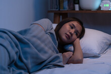 Stressed Person. Asleep, Sleep Asian Young Woman, Girl Under Blanket, Suffering From Insomnia, Awake At Night In Bedroom, Tired And Exhausted. Frustrated People With Problem, Exhausted On Nightmares.