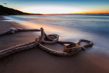 Poster - Scenic view of boat rope on the beach against with sky during sunrise