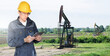 © scharfsinn86 - Engineer with a digital tablet on the background of oil rigs