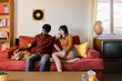 © Austockphoto - couple at home in living room with dog on sofa