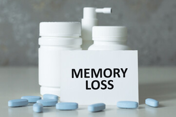 Wall Mural - MEMORY LOSS text on a card on the table next to the jar with the medicine