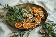 Getrocknete Orangenscheiben Und Eukalyptus Auf Goldenem Teller Dekoriert, Weihnachtsdeko Minimalistisch Gestaltet
