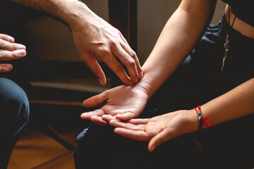 Detail of traditional chinese medicine doctor making palpations on a teenager girl patient in the consult previous to a therapy