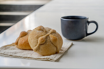 Traditional  mexican bread of the dead and cup of coffee on white table