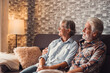 © Daniel - Old couple of two happy pensioners having fun together relaxing on the sofa of beauty and cute house. Portrait of seniors or mature people in love looking at the window.
