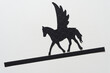 glyph or dingbat of pegasus (winged horse) cutout and black paper stripe sloping downwards