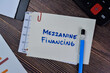 Concept of Mezzanine Financing write on sticky notes isolated on Wooden Table.