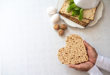 Wall Mural - Woman's hands holds Matzah shape of heart. Traditional of Jewish Holiday on Passover. Home symbol of lovely family. top view, layout. love and care. Gift for lovers. Feeling in love and blissful life