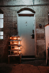 Sticker - Containers with candles glowin in it in front of an old door