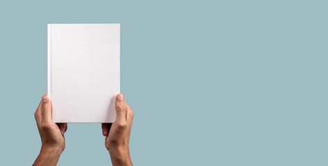 Poster - Paper business book mock up in male hand on blue banner with copy space. Hard cover mockup, blank template