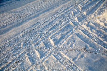 Wall Mural - Traces of a car in the snow as a background.