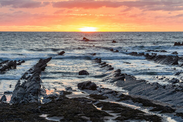 Wall Mural - Beautiful sunset landscape image of Welcome Mouth Beach in Devon England with beautiful rock formations