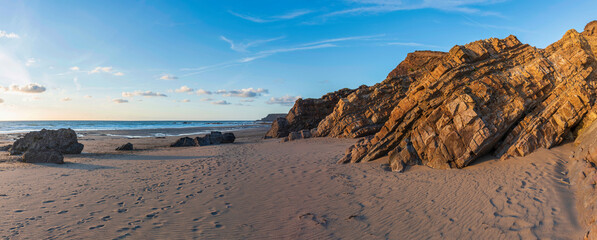 Wall Mural - Stunning Summer sunset landscape image of Widemouth Bay in Devon England with golden hour light on beach