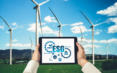 Green business transformation for environment saving and ESG business concept. Businessman using tablet to set corporate goal toward environmental friendly management and alternative clean energy use.