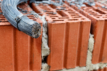  Use of knitting wire for reinforcement in the construction of a house. The prepared knitting wire lies on the brickwork. Armature bond. Close-up.