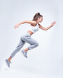 © andy_gin - Sports woman runner on a white background. Photo of an attractive woman in fashionable sportswear. Dynamic movement. Side view. Sports and healthy lifestyle