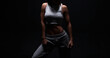 © andy_gin - Athletic fitness woman posing in the studio on a dark background. Photo of an attractive woman in fashionable sportswear. Sports and healthy lifestyle