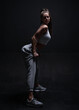 © andy_gin - Athletic fitness woman posing in the studio on a dark background. Photo of an attractive woman in fashionable sportswear. Sports and healthy lifestyle