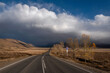 road asphalt mountains clouds sky trees storm