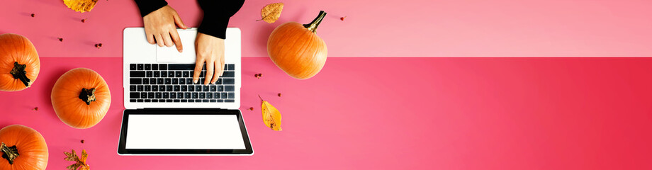 Autumn pumpkins with person using a laptop computer