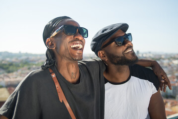 close-up of happy african gay men spending time together. two young bearded men in black glasses sta