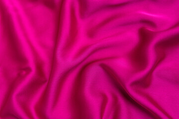 Texture of bright pink tissue silk or satin. Fabric fuchsia or crimson-colored color. Abstract background