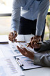 © crizzystudio - Business executives analyze data documents and calculating about fee tax at an office Image of business people working together analyzing calculations using a laptop calculator and graph