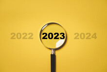 2023 Year Inside Of Magnifier Glass Among 2022 And 2023 For Focus And Concentrate Of New Business Year , Merry Christmas  And Happy New Year Concept.