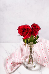 Wall Mural - Postcard with red colorful summer roses  flowers against grey textured background in  vase. Selective focus. Still life.