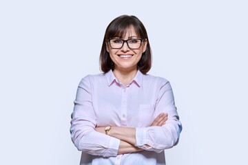 Wall Mural - Portrait of confident middle-aged business woman on light background