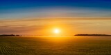 Fototapeta  - Landscape view of an orange-colored sunset over the prairies