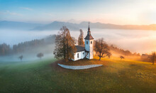 Aerial Drone View Of Small Beautiful Church On A Mountain In Slovenia At Dawn. Beautiful Autumn Morning Landscape